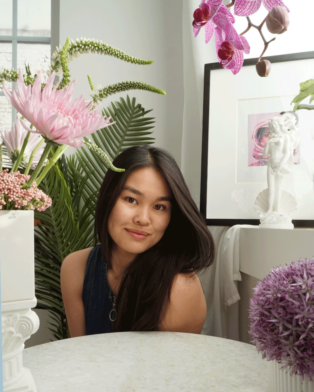 photograph of Sara surrounded by flowers smiling